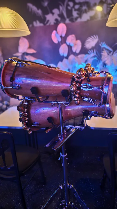 Batá drums with their bells, lit up on stage